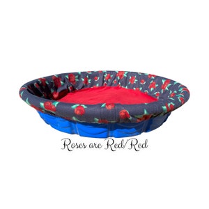 May include: A blue plastic pet bed with a red fleece liner and a black and red floral print fabric cover. The text "Roses are Red/Red" is printed below the bed.