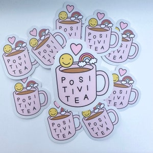 May include: A set of pink and white stickers featuring a cartoon mug with the text "Positivi Tea" and a rainbow and smiley face.