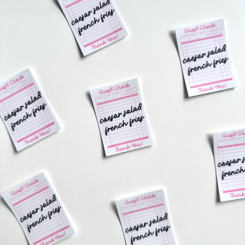 Pu&ograve; includere: Sei scontrini bianchi per ospiti con linee rosa e testo nero. Ogni scontrino dice "Guest Check" in alto e "Caesar salad french fries" in corsivo. In fondo a ogni scontrino c'&egrave; scritto "Thank You!"