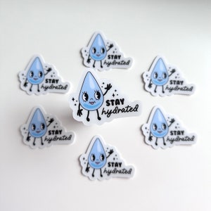 Puede incluir: Conjunto de siete pegatinas de gota de agua azul y blanca con el texto "Stay hydrated" en cada pegatina.