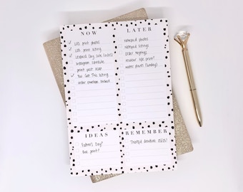 May include: A set of four white notepads with black polka dots. Each notepad has a different heading: "NOW", "LATER", "IDEAS", and "REMEMBER". The notepads are on a gold glitter background.