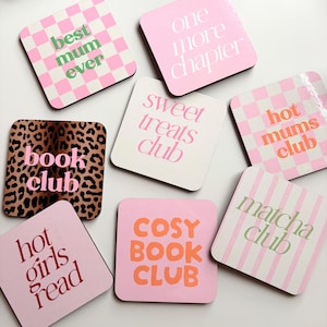 Peut inclure: Un ensemble de huit dessous de verre carrés avec divers motifs et textes, notamment best mum ever, one more chapter, sweet treats club, hot mums club, book club, hot girls read, cosy book club et matcha club en rose, blanc et marron.