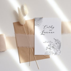 May include: A white card with black ink announcing the wedding of Cathy and Luciano. The date is Saturday, March 28, 2020. The card is decorated with a floral design.