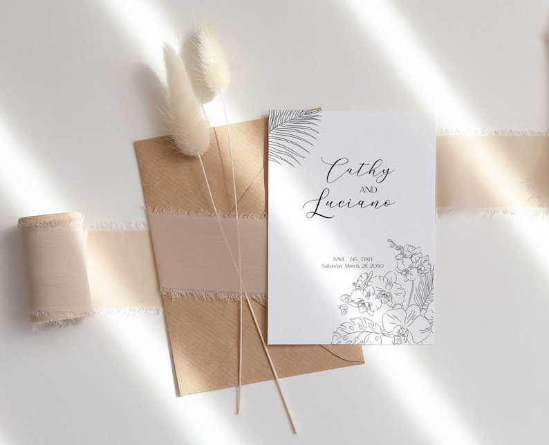 May include: A white card with black ink announcing the wedding of Cathy and Luciano. The date is Saturday, March 28, 2020. The card is decorated with a floral design.