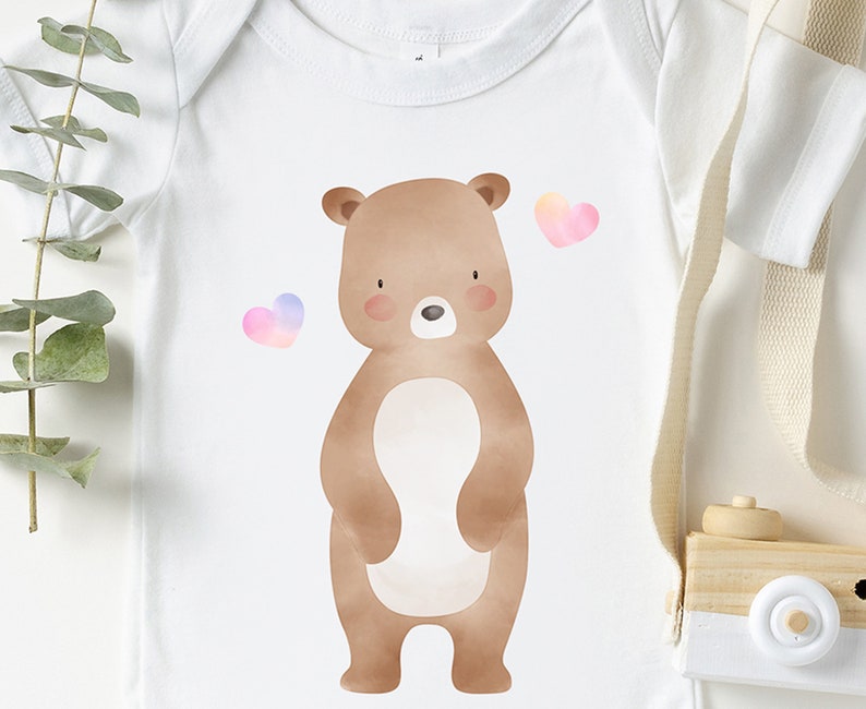May include: A white baby onesie with a brown watercolor bear and two pink and purple watercolor hearts.