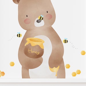 May include: A brown bear holding a pot of honey with the word "Honey" written on it. There are several yellow honeycombs and bees flying around the bear.