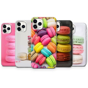 May include: A set of colourful phone cases featuring a pattern of macarons. The cases are available in pink, black and white.