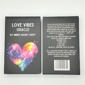 May include: A black box set of "Love Vibes Oracle" cards by Inner Haven Tarot. The front features a colourful heart design with a galaxy-like pattern. The back of the box contains text describing the deck's purpose and features.