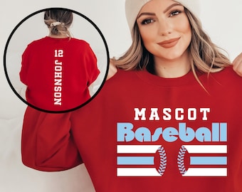 May include: Red sweatshirt with the text "MASCOT Baseball" in white and blue lettering. The sweatshirt has a blue and white striped design with a baseball graphic.