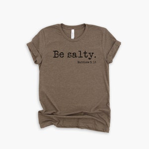 May include: A brown t-shirt with the text "Be salty. Matthew 5:13" printed on the front.