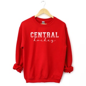 May include: Red sweatshirt with white text that reads "CENTRAL hockey" in a vintage style font.