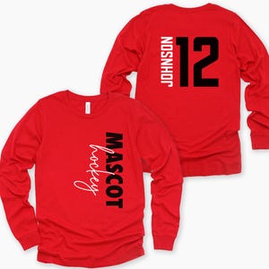 May include: Red long-sleeve t-shirt with black text that says "MASCOT hockey" on the front and "JOHNSON 12" on the back.