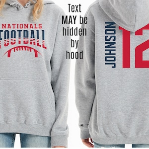 May include: Gray hooded sweatshirt with the text "NATIONALS FOOTBALL" in blue and red on the front and the text "JOHNSON 12" in blue and red on the back.