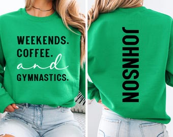 May include: A green sweatshirt with the words "WEEKENDS. COFFEE. and GYMNASTICS." in black and white. The back of the sweatshirt has the name "JOHNSON" printed vertically in black. The sweatshirt is a crew neck style.