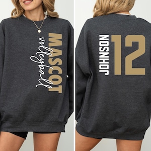 May include: A dark gray sweatshirt with the words "MASCOT volleyball" printed on the left side and the words "JOHNSON 12" printed on the right side.