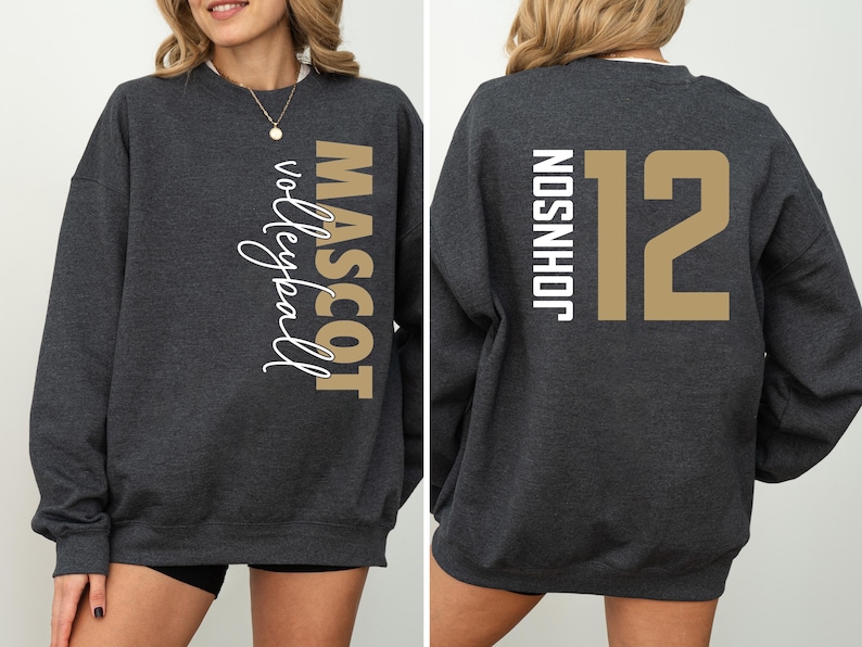 May include: A dark gray sweatshirt with the words "MASCOT volleyball" printed on the left side and the words "JOHNSON 12" printed on the right side.