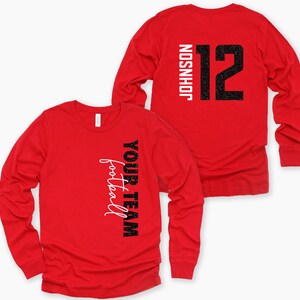 May include: Two red long-sleeve shirts. One shirt has the words "YOUR TEAM football" printed vertically in black and white. The other shirt has the name "JOHNSON" and the number "12" printed on the back in black and white.
