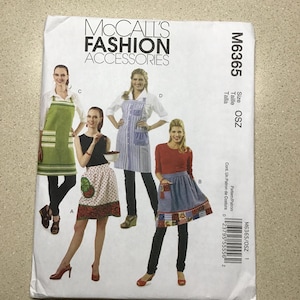 May include: McCall's Fashion Accessories sewing pattern M6365. The pattern features aprons in various styles, with images of the finished products. The package includes size OSZ. The cover is white with images of aprons.