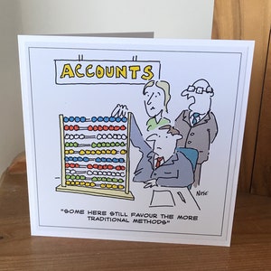 May include: A cartoon illustration of a person using an abacus to do accounting. The sign above the person reads "Accounts". The caption below the image reads "Some here still favour the more traditional methods."