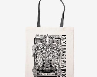 May include: Cream-colored tote bag with black handles and a detailed black and white graphic. The graphic features two angels, a star, and text that reads "The Dawn of the Ego Divine" and "Esmeraker Tattoo".