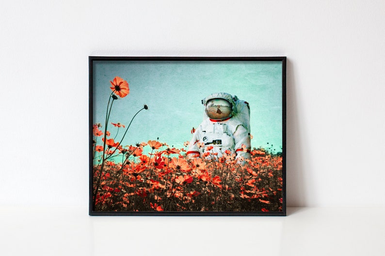 K&ouml;nnte beinhalten: Ein Astronaut in einem wei&szlig;en Raumanzug steht in einem Feld mit orangefarbenen Kosmosblumen vor einem blauen und gr&uuml;nen Himmel.