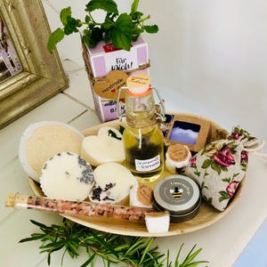 Peut inclure: Un panier-cadeau rempli de produits de bain et de corps, comprenant une bouteille d'huile, un savon, des sels de bain, des bougies et un baume à lèvres. Le panier est fait de matériaux naturels et a un aspect rustique. Ce panier-cadeau est parfait pour quelqu'un qui aime se faire dorloter.