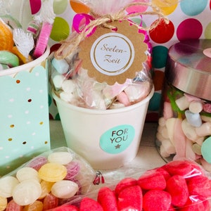 Könnte beinhalten: Drei Behälter gefüllt mit verschiedenen Süßigkeiten, darunter Marshmallows, harte Bonbons und Gummibärchen. Die Behälter sind mit Aufklebern verziert, auf denen "For You" und "Seelen-Zeit" steht.