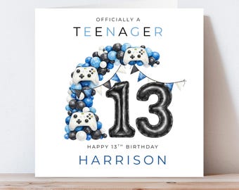 May include: A white birthday card with the text "OFFICIALLY A TEENAGER" in blue. The card features a balloon design with the number "13" and controller graphics. The text "HAPPY 13TH BIRTHDAY" and a name are also included.