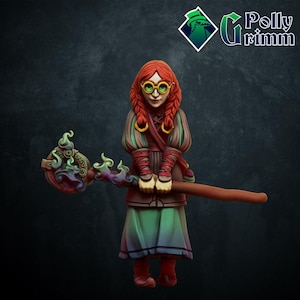 Puede incluir: Una figura en miniatura de una maga con cabello rojo, vestida con un vestido verde y marrón, sosteniendo un bastón con una llama verde y un diseño circular. Lleva gafas redondas y tiene una expresión seria.