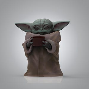 K&ouml;nnte beinhalten: Eine 3D-gerenderte Figur eines gr&uuml;nen, au&szlig;erirdisch aussehenden Charakters, der eine braune Tasse h&auml;lt. Die Figur hat gro&szlig;e Ohren, eine beige Robe und einen neutralen Gesichtsausdruck. Der Hintergrund ist ein Grauton.