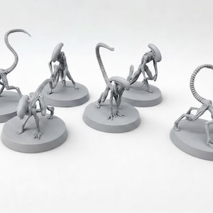 Könnte beinhalten: Sechs graue Alien-Figuren in verschiedenen Posen, jeweils auf einer kreisförmigen Basis. Die Figuren haben längliche Köpfe, schlanke Körper und gebogene Schwänze, was auf ein Science-Fiction- oder Fantasy-Thema hindeutet.