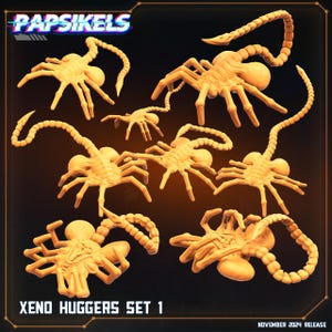 May include: A set of nine 3D printed alien creature figures, known as Xenomorphs, in a light brown color. The figures are posed in various positions, with their tails curled around their bodies. The figures are all facing the camera, and the text "XENO HUGGERS SET 1" is printed below the figures.