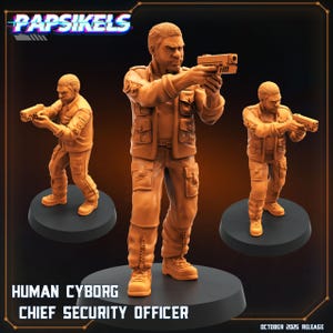Könnte beinhalten: Drei orangefarbene Human Cyborg Chief Security Officer-Figuren, die jeweils eine Waffe halten. Die Figuren stehen auf schwarzen, kreisförmigen Sockeln. Der Text "Papsikels" steht oben und "Human Cyborg Chief Security Officer" unten. Veröffentlichungsdatum: Oktober 2025.