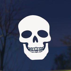 May include: White skull sticker with a simple design. The skull has a toothy grin and empty eye sockets.