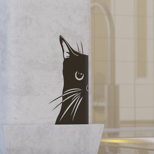 May include: White ceramic planter with a black cat silhouette design. The planter has a square base and a rectangular body. The cat is looking to the right and has a small, round nose and large, almond-shaped eyes.