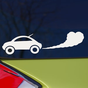 May include: White vinyl sticker of a car with a white smoke trail coming out of the exhaust pipe. The sticker is on a green car window.