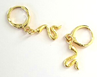 May include: A pair of gold hoop earrings with a snake charm dangling from each hoop.