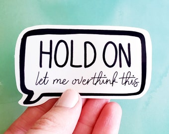 May include: White sticker with a black speech bubble that says "HOLD ON let me overthink this".