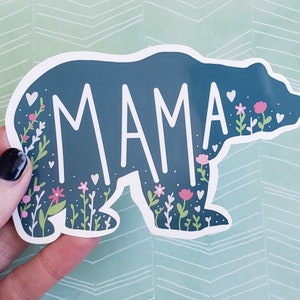 May include: A blue bear silhouette with white floral accents and the word "MAMA" in white lettering.