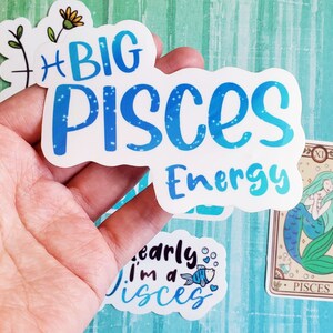 May include: A set of four stickers featuring the zodiac sign Pisces. The stickers are white with blue text and glitter accents. One sticker says "Big Pisces Energy", another says "I'm a Pisces", and the third is a mermaid with the text "Pisces".