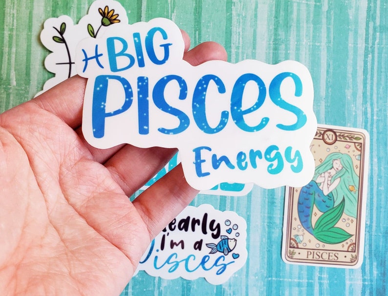 May include: A set of four stickers featuring the zodiac sign Pisces. The stickers are white with blue text and glitter accents. One sticker says "Big Pisces Energy", another says "I'm a Pisces", and the third is a mermaid with the text "Pisces".