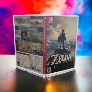 May include: A Nintendo Switch game case for The Legend of Zelda: Breath of the Wild. The case is red and white with a picture of Link standing on a mountaintop. The text "The Legend of Zelda: Breath of the Wild" is printed on the case.