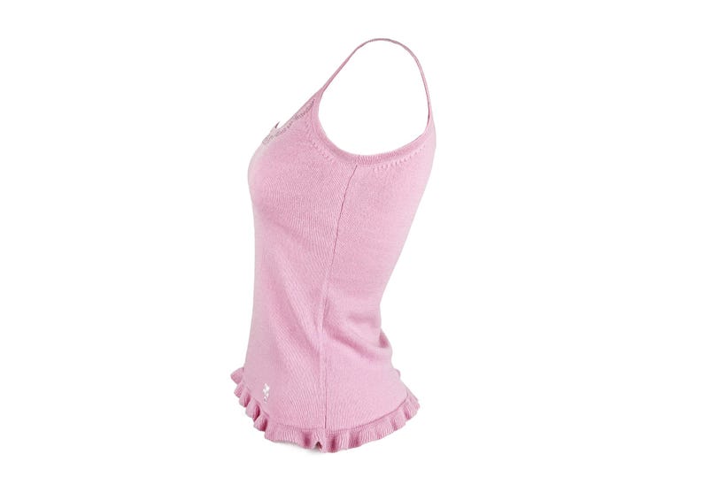 Op de afbeelding: Een lichtroze camisole met spaghettibandjes. De top heeft een getailleerd silhouet, een gefranjerde zoom en een klein geborduurd detail bij de zoom. De stof lijkt een zacht gebreid materiaal te zijn, geschikt voor warm weer.