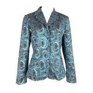 May include: A teal and brown patterned blazer with a two-button closure and two front pockets. The jacket features a repeating swirl design. The blazer is a tailored fit and has a notched collar.