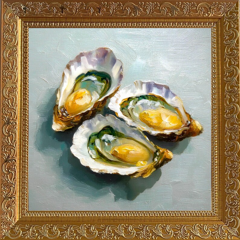 May include: An oil painting of three opened oysters with yellow and green interiors, set against a light blue background. The artwork is framed in a gold, ornate frame, adding a touch of elegance to the still life.