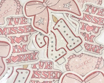 May include: A set of pink and white stickers with glitter and a sparkly finish. The stickers feature a bow, a candle with the number 21, and the text "I've missed you I'm sorry".