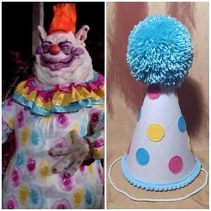 May include: A white party hat with blue, yellow, and pink polka dots and a blue pom-pom on top.