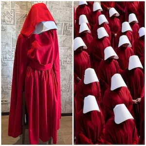 May include: A bright red long-sleeved dress with a matching red hooded cloak and a white bonnet. The dress features a fitted waist and a pleated skirt. The ensemble is displayed on a mannequin next to a reference image of multiple figures wearing identical red dresses, cloaks, and white bonnets.