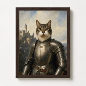 Op de afbeelding: Een ingelijste print met een kat in middeleeuws harnas, tegen een achtergrond van een kasteel en lucht. De kat, met een tabby vacht, is het centrale figuur. Het donkerbruine frame contrasteert met de metallic tinten van het harnas.
