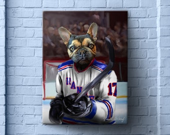 Op de afbeelding: Canvas print met een Franse Bulldog in een New York Rangers hockeytrui, met een hockeystick. De trui is wit met blauwe en rode accenten, en het nummer 17 is zichtbaar. De achtergrond toont een ijsbaan en toeschouwers.